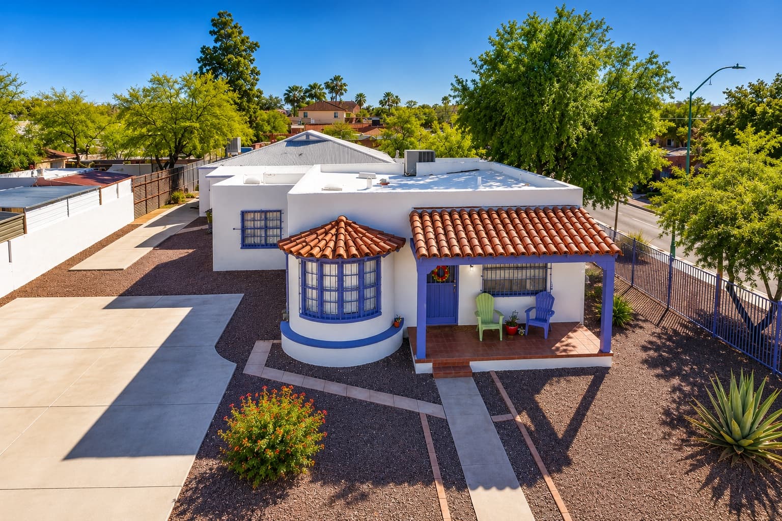 A white Spanish-revival home at 1304 E Linden St with a round bay turret and tiled porch